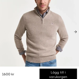 Beige half zip stickad tröja GANT - Original pris 1600kr. Passar er som har på er S. Snygg beige stickad tröja från GANT med half zip och liten broderad logga på bröstet. Tröjan har ribbade muddar och hög krage, perfekt för lager på lager. Passar dig som gillar klassisk och stilren look.