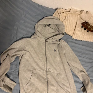 Ralph Lauren Zip - Snygg Raffe zip i storlek M! Den är i väldigt bra skick, använd enstaka gånger. Saknar däremot snöret till luvan… kan tänkas byta mot skor men pengar från min sida ochså!