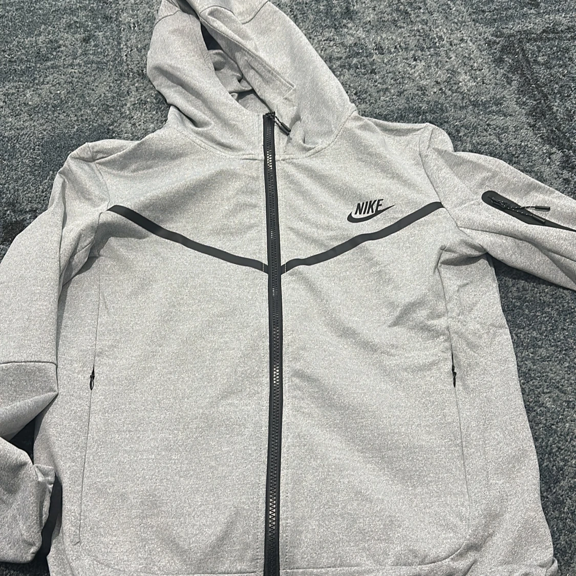 Grå vindjacka från Nike med huva