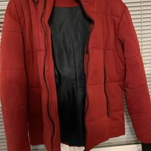 Röd pufferjacka från Zara Man XL - Säljer en röd pufferjacka från Zara Man i storlek XL. Jackan har huva med snörning, jackan är perfekt för kalla dagar. 