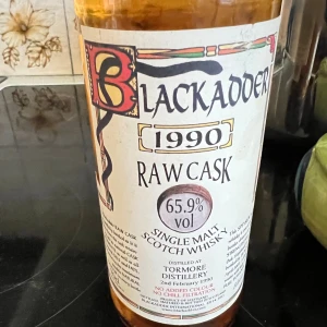 Blackadder Raw Cask 1990 Single Malt Scotch Whisky - Exklusiv single malt whisky från Blackadder, destillerad 1990 vid Tormore Distillery. Raw Cask, 65,9% vol, ej kylfiltrerad och utan tillsatt färg. Flaskans etikett är i gott skick, perfekt för samlare och whiskyentusiaster.