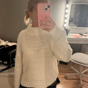 Vit stickad tröja med hög krage - Säljer en vit stickad tröja med hög krage och grov ribbad struktur. Töjan är i fint skick och endast använd ett fåtal gånger. Stl M men passar även som S.