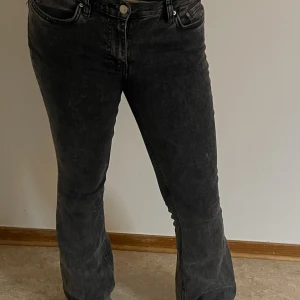 Svarta bootcut jeans från gina - Grå/svarta bootcut jeans från ginatricot. Liten fläck på benet och ena fickan är sönder(tror man kan sy igen det) 