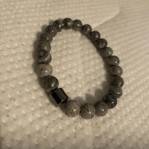 Grått pärlarmband med marmormönster - .