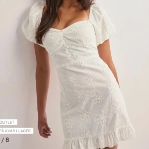 Intressekoll på min studentklänning! - Supersöt vit kort klänning med puffärmar och broderade blommor. Klänningen har en v-ringad urringning, volangkant nedtill och är tillverkad i bomull. Köpt för 599kr, inga defekter endast använd efteråt på studentskivan ej utspring! 