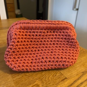 Virkad necessär  - Unik handgjord clutch necessär i korallrosa färg, virkad med T-shirt garn som ger en cool och chunky look.🤩