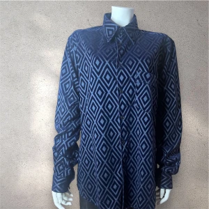 Blå mönstrad skjorta - Unik skjorta i mörkblå sammet med geometriskt rutmönster. Klassisk krage, knäppning framtill och en bröstficka. Skjortan har lång ärm och loose passform, perfekt för dig som gillar att sticka ut med coola detaljer och mjukt material. #skjorta