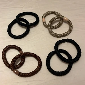 Flätade tofsar i olika färger - Säljer flera oanvända snygga flätade tofsar i svart, beige och brunt. Tofsarna är tillverkade av ett slitstarkt syntetmaterial med små plastdetaljer. Perfekt accessoar för att ge din outfit en cool touch.