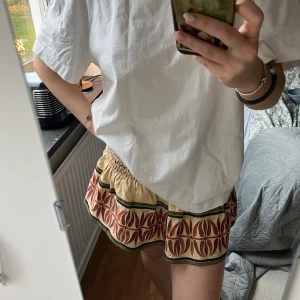 Snygg Zara kjol - Säljer denna skitsnygga Zara kjolen med mönster. Går att styla till massa olika toppar och tshirts, perfekt till sommaren. Har inbyggda shorts och snöre med pärlor. Storlek xs men skulle säga att den snarare är s, kan passa M också då den är ganska töjbar. Säljer då den inte kommit till användning och behöver resna garderoben 