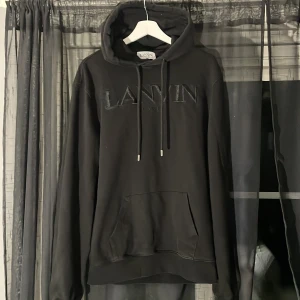 hoodie från Lanvin Paris - Svart hoodie från Lanvin Paris med broderad logga framtill. Klassisk modell med huva. Man ser att hoodien är andvänd. Har inget kvitto då jag köpte den från Plick och går ner från vad jag köpte den för pågrund av de. Hör av dig vid minsta fundering. 
