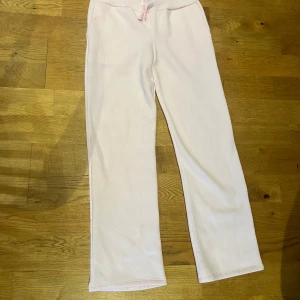 Ljusrosa mjukisbyxor från 157 - Säljer ett par ljusrosa mjukisbyxor från 157 med ribbad midja och snörning. Byxorna har raka ben och är tillverkade i mjukt bomullsmaterial, perfekta för chill dagar. Enkel design utan fickor eller mönster.