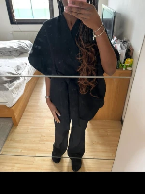 Cardigan med knytband och capeärmar  - Svart omlottkofta med knytband i midjan. Koftan har vida ärmar och man kan anpassa koftan efter hur tight man vill ha den. Är vanligtvis en storlek xs-s🫶🏽