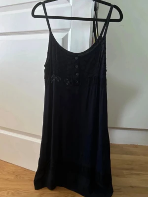 Svart spetsklänning med knappar - Super fin miniklänning utan resårband. Står ingen storlek på den eller var den är ifrån, men skulle gissa på att det är storlek S/M.
