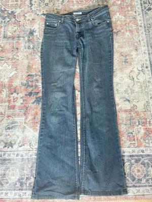 Blå bootcutjeans  - Blå bootcutjeans med broderade bakfickor!!🩷Något slitna vid hälarna och dragkedjan har en tendens att åka ner (därav kan pris diskuteras) men i övrigt väldigt gott skick 🥰 Skriv för mått, fler bilder osv!