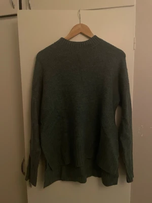 Grön, grå  stickad tröja Vero Moda - En grön, grå stickat tröja som är lite längre bak än fram 