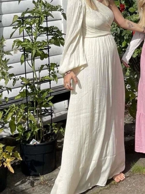 Lång klänning  - Säljer en långklänning med oneshoulder och lång ärm. Använd fåtal gånger