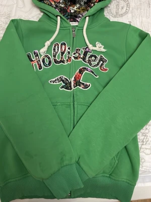 Hollister tjocktröja - Grön hollister hoodie i storlek M har några små fläckar som knappt syns men går inte bort. Silkesmaterial i luvan.