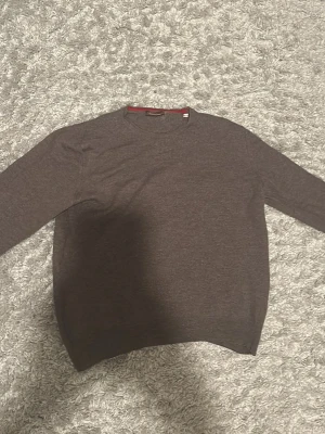 Brun stickad tröja från Stenströms - Säljer en brun stickad tröja från Stenströms i storlek M. Tröjan har rund halsringning, långa ärmar och diskreta ribbade muddar vid ärmslut och nederkant. Perfekt för lager på lager under höst och vinter.