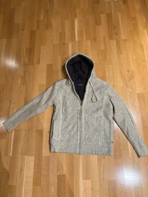 Beige cardigan - Säljer denna schyssta beiga cardigan med teddy päls luva perfekt nu till vintern. Storleken är L men lutar mer åt M hållet. Har inga defekter mer än att den är lite nopprig men annars i fint skick, hör av er om ni har frågor eller diskussion kring pris.