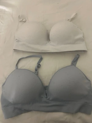 2 ribbade toppar från Lindex M - Säljer två ribbade toppar från Lindex i storlek M. En är vit och den andra är ljusblå, båda med justerbara axelband och vadderade kupor. Tillverkade i återvunnen polyesterblandning för en mjuk och stretchig känsla. För båda 150kr och för en 65kr