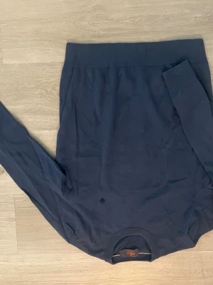 Mörkblå bomullströja från Morris - Snygg mörkblå långärmad tröja från Morris i 100% pima bomull. Klassisk rund halsringning med ribbade muddar och diskret Morris-logga broderad framtill. Perfekt för dig som gillar stilrena och bekväma plagg.