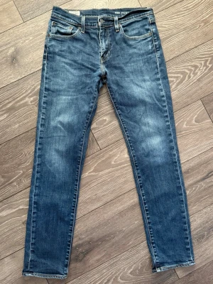Levi's 511 blå jeans slim fit - Säljer ett par klassiska Levi's 511 Performance jeans i blå tvätt. Modellen har slim fit med normal midja och raka ben. Jeansen har fem fickor, snygga slitningar och kontrastsömmar. Perfekta till sneakers eller boots och funkar året runt.