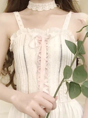 Söt vit klänning med rosa snörning - Choker + klänning ingår. Helt ny med tags. Storlek S men uppskattar att den passar XXS-S pga shirring i ryggen.