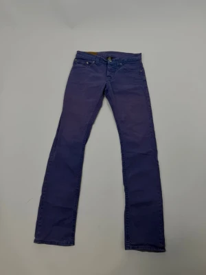 Blå Dondups - Säljer ett par blå jeansbyxor med klassisk femficksdesign och raka ben. Byxorna har normal passform och är tillverkade i ett mjukt bomullsmaterial. Perfekta för dig som gillar en enkel och stilren look.