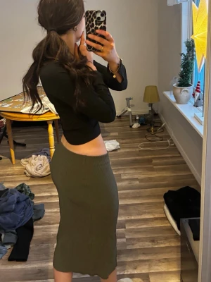 Olivgrön ribbad långkjol - Säljer en olivgrön ribbad långkjol med tight passform. Superbekväm och stretchig i materialet