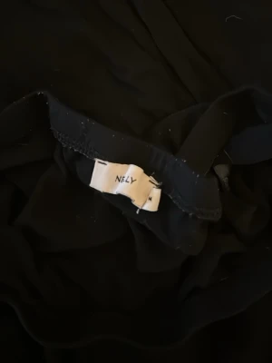 Svart tjol en mini och en maxi - Enkla svarta tjolar från Black Premium och Nelly med elastisk midja. Kjolen har en clean look utan mönster eller detaljer och är gjord i ett mjukt, lätt material som känns bekvämt. Perfekt till sneakers eller boots för en chill stil.