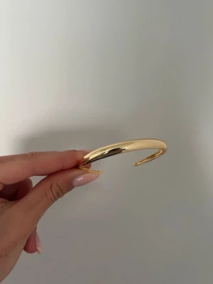 Guldig armring i minimalistisk stil - Säljer en stilren och chunky armring i 18k guldplatering, superfin 