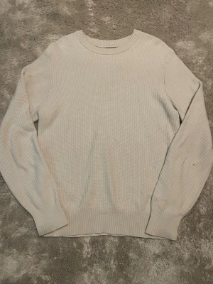 Beige stickad tröja J.Lindeberg - Säljer en stilren beige stickad tröja från J.Lindeberg i storlek M. Tröjan har rund halsringning, ribbade muddar och är långärmad. Perfekt för lager på lager under höst och vinter. Enkel och clean design som passar till det mesta. Skickas endast med PostNord. Om annat fraktsätt väljs av Plick, avbryts köpet.