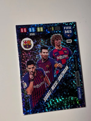 Adrenalyn Barca front 3 Rare kort  - Säljer en sportig väst i blått och rött med FC Barcelonas klubbmärke och Rakuten-tryck. Västen har klassisk sportdesign, ärmar saknas och den har en rak passform. Perfekt för dig som gillar fotboll och vill visa ditt lagstöd.