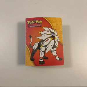 Pokémon kort och kortalbum med Solgaleo & Lunala - Säljer ett Pokémon Trading Card Game album med Solgaleo på framsidan och Lunala på baksidan. Albumet har en färgstark design i rött, orange och lila med coola motiv. Inuti finns plastfickor med samlarkort, perfekt för att hålla ordning på din samling.
