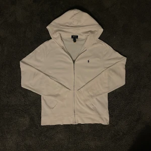 Ralph Lauren Zip up - Riktigt snygg zip från Ralph Lauren. Tröjan är XL i barnstorlek vilket motsvarar S i vuxen storlek. Tröjan har en väldigt liten fläck som visas på sista bilden. Fläcken syns endast på nära håll.  Hör av dig vid frågor.