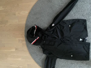 Moncler Vindjacka svart - Svart Moncler Windbreaker. Storlek 2 (Motsvarar M). NFC scan fungerar. Tar ej emot byten och priset går tyvärr ej att diskuteras. Fråga gärna för fler bilder eller funderingar. 