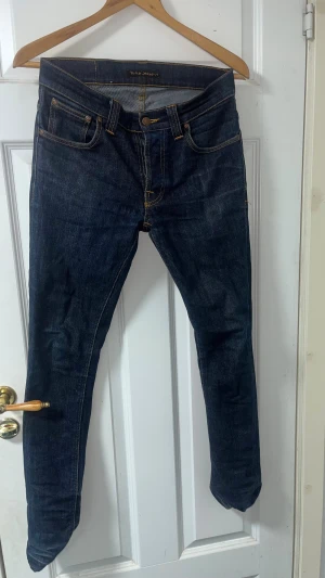 Nudie Jeans Grim Tim - Tja! Jag säljer mina Nudie Jeans Grim Tim eftersom de inte passar mig längre och har tröttnat på de. De är i ett mycket bra skick och desto mer du använder jeansen desto mer wash kommer du få! Finns ganska få utav just den här modellen och färgen!