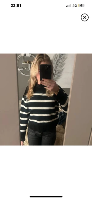 Svartvit randig stickad tröja - Snygg stickad tröja med breda svarta och vita ränder. Modellen har rund hals och ribbade muddar vid ärmslut och nederkant. Perfekt för dig som gillar en klassisk look med lite edge.