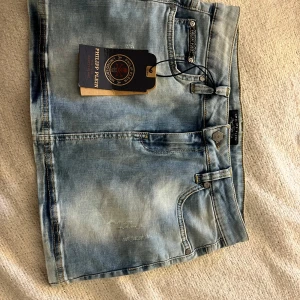 Philipp Plein ljusblå jeanskjol - Skit snygg jeans kjol från Philipp Plein i sl M. Säljs pgr av att jag inte haft andvänding för dem. Köpta för 1699kr dessa säljs inte längre men på 5 sliden finns en liknade bild🩷