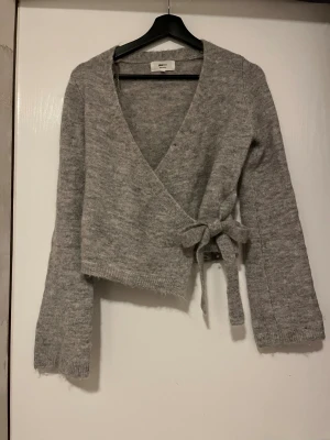 Grå omlottkofta från Gina Tricot - Grå omlottenkofta från Gina Tricot. Aldrig använd så i mycket bra skick! Finns katt och hund i hemmet☺️