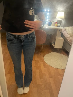 Blå bootcut jeans från LTB - Snygga blå jeans från LTB med bootcut passform och låg midja. Klassisk femficksmodell med slitningar och tvättade detaljer. Ett litet hål i en av bakfickorna men märks inte av. Lite korta för mig som är 162 cm  💙