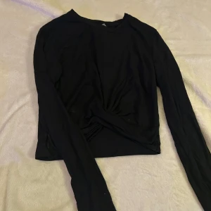 Långärmad tröja  - Säljer en svart långärmad tröja från H&M i storlek S. Tröjan har en liten knytning vid magen som ger en fin detalj.🩷