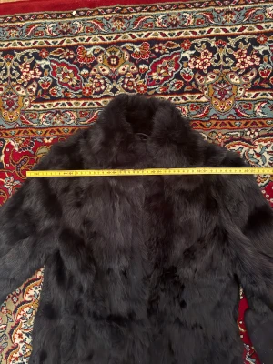 Svart pälsjacka med hög krage - Säljer en svart pälsjacka med hög krage och lång ärm. Jackan har en loose passform och är tillverkad i mjukt ÄKTA kaninpäls som ger en lyxig och varm känsla. Perfekt för dig som vill ha en statement piece i garderoben. Fråga gärna om ni har frågor! Nypris var 2995kr 