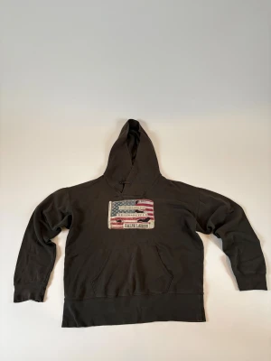 Ralph Lauren hoodie - Säljer en grå hoodie från Ralph Lauren med en stor amerikansk flagga på framsidan. Ok skick 