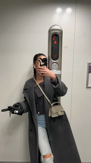 Mörkgrå lång kappa - Säljer en stilren mörkgrå kappa med bred krage och dubbelknäppning. Jackan är lång och har en loose passform. Lite nopprig men fortfarande lika fin!