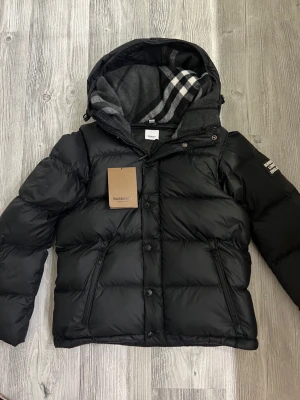 Burberry jacka - Hej! Jag säljer nu min burberry jacka som är i jättebra skick den är använd väldigt lite och sparsamt och har inga defekter eller liknande. Jag säljer den pågrund av att den inte riktigt passar min personliga stil. Den är äkta och köpt online. Den kan även bli som en väst om man tar av armarna och den är perfekt för vintern och hösten. Hör av dig vid minsta lilla fråga!👍