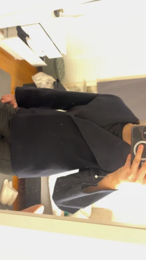 Mörkblå kappa från Gina Tricot - Snygg mörkblå kappa från Gina Tricot med bred krage och stilren design. Jackan har lång ärm och är tillverkad i ett mjukt ullmaterial som känns lyxigt. Perfekt för dig som gillar minimalistisk och clean look.