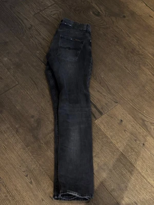 Nudie Jeans - Grim Tim - Nudie Jeans säljes                                                           Modell: Grim Tim.                                                             Storlek: 32/34.                                                                       Bra skick.                                                                            Mörk Gråa