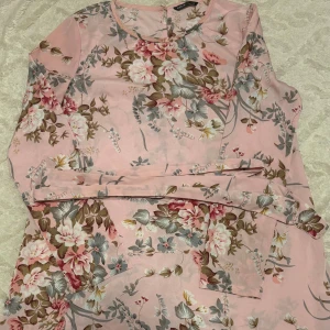 Klänning  - Säljer denna fina rosa korta klänning med blommor, perfekt till sommaren. Den är endast använd en gång och kommer tyvärr inte till användning längre. Klänningen är i mycket fint skick. Storlek: 36. Från SHEIN. Pris: 80 kr