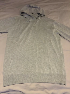 Ljusgrå stickad hoodie med huva - 100% merino ull tröja, grå, använd 2-3 gånger(nyskick). Storlek S. Snygg nu till vintern och ett snyggt bas plagg! Kontakta vid frågor!